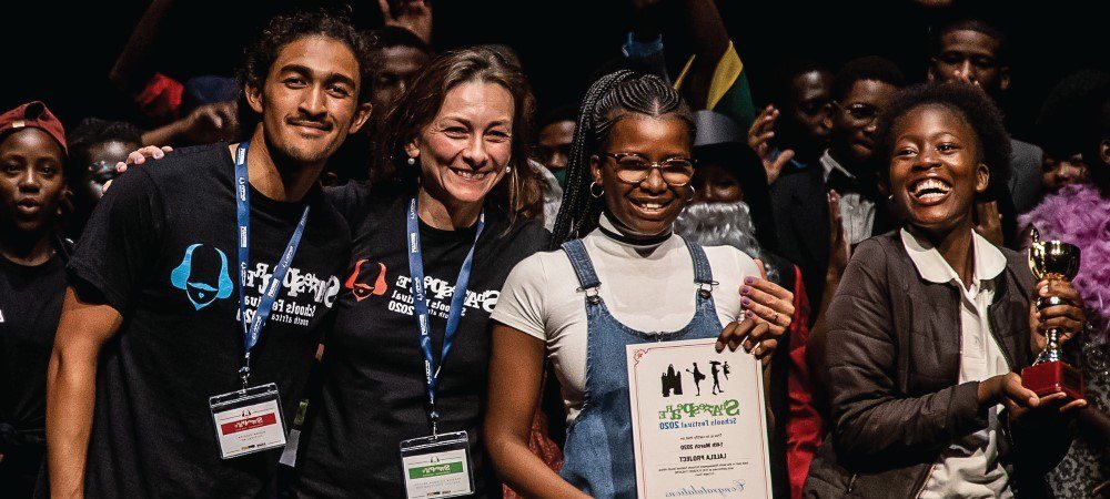Students celebrating with an award certificate and trophy